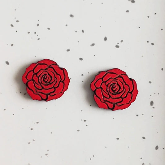 Red rose-shaped stud earrings on a white speckled background.