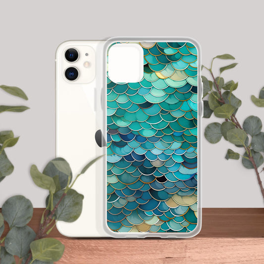 Clear iPhone 11 case with a teal and blue fish scale pattern displayed with an iPhone on a wooden surface with greenery in the background.
