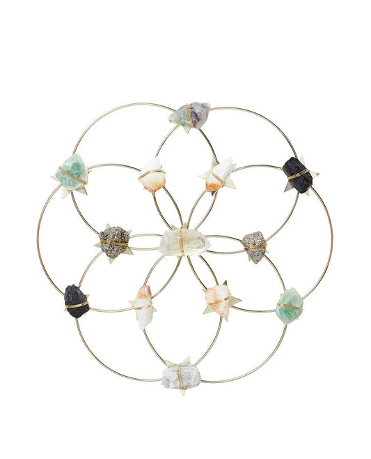 Crystal grid healing wall decor in a Flower of Life pattern with various raw quartz and gemstones on a white background.