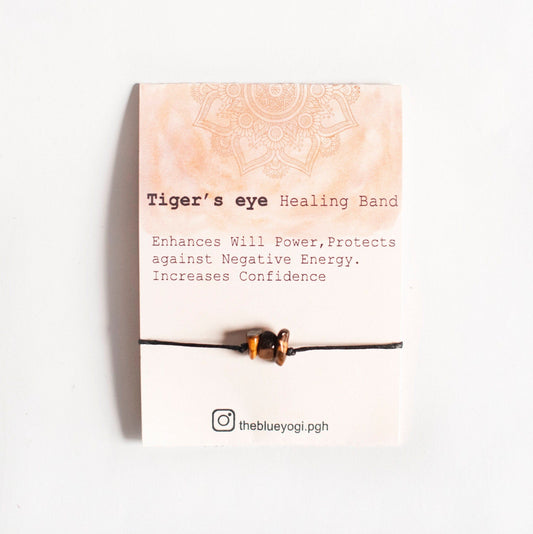Tiger's eye healing band against a white background with text describing its benefits: enhances willpower, protects against negative energy, increases confidence.